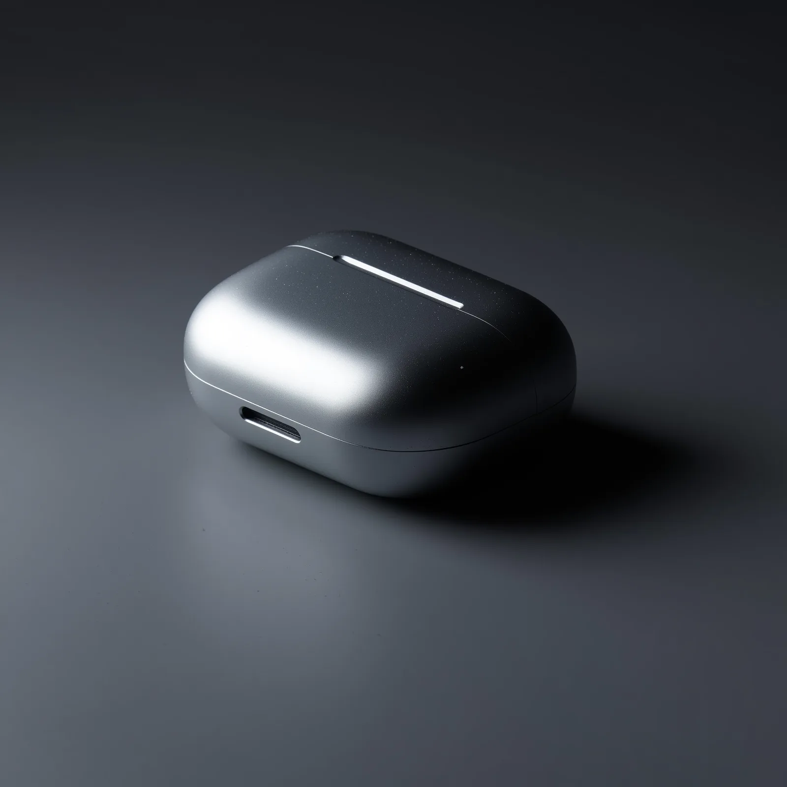 An unbranded matte aluminium case resting at an angle on an unbroken dark grey backdrop, one long highlight along its machined edge.